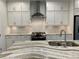 Well-designed kitchen showcases an island with a waterfall marble countertop and stainless appliances at 407 Johnson Ct, Alpharetta, GA 30009