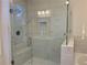Bright glass shower with marble tile, bench, niche, and overhead lighting at 407 Johnson Ct, Alpharetta, GA 30009