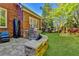 Beautiful backyard featuring a built-in grill and stone patio, with a lush lawn and landscaping at 7940 Royal Melbourne Way, Duluth, GA 30097
