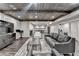 Spacious basement with wooden ceiling, gray sofa, accent rug, and open floor plan at 7940 Royal Melbourne Way, Duluth, GA 30097