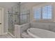 This bathroom features a seamless glass shower and soaking tub at 7940 Royal Melbourne Way, Duluth, GA 30097