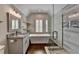 Modern bathroom features a standalone tub, glass-enclosed shower, and elegant fixtures for a spa-like experience at 7940 Royal Melbourne Way, Duluth, GA 30097