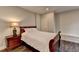 Comfortable bedroom with a dark wood bed frame, bedside table, and natural light at 7940 Royal Melbourne Way, Duluth, GA 30097