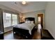 Cozy bedroom with a large window, dark wood floors, and a comfortable bed, perfect for relaxation at 7940 Royal Melbourne Way, Duluth, GA 30097