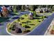 Landscaped community roundabout featuring a gazebo, manicured shrubs, and a lush green lawn at 7940 Royal Melbourne Way, Duluth, GA 30097