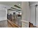 Upstairs hallway with dark hardwood floors and railing plus a barn door at 7940 Royal Melbourne Way, Duluth, GA 30097