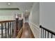 Upstairs hallway features dark hardwood floors and decorative railings at 7940 Royal Melbourne Way, Duluth, GA 30097