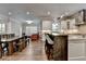 Open-concept kitchen and dining area with an island, seating, and modern lighting at 7940 Royal Melbourne Way, Duluth, GA 30097