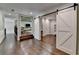 Open-concept living space featuring sliding barn doors, hardwood floors, and a staircase at 7940 Royal Melbourne Way, Duluth, GA 30097
