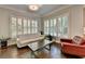 Comfortable living room with hardwood floors, white sofa, red chair, and natural light at 7940 Royal Melbourne Way, Duluth, GA 30097