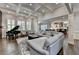 Open-concept living room featuring coffered ceilings, hardwood floors, and large windows, with a view to the kitchen at 7940 Royal Melbourne Way, Duluth, GA 30097