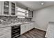 Close-up of the basement wet bar with white cabinets and granite countertops at 7940 Royal Melbourne Way, Duluth, GA 30097
