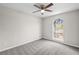 Cozy bedroom with a large window, neutral carpet, and a ceiling fan at 10331 Wrens Dr, Jonesboro, GA 30238