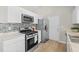 Bright kitchen features stainless steel appliances, white cabinets, and stone countertops at 10331 Wrens Dr, Jonesboro, GA 30238