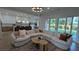 Open-concept living room with a comfortable sectional sofa, modern lighting, and access to the backyard at 315 Hillcrest View Dr, Suwanee, GA 30024