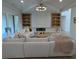 Bright living room featuring a comfortable sofa, fireplace, custom built-ins, and modern lighting fixture at 315 Hillcrest View Dr, Suwanee, GA 30024