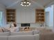 Bright living room featuring a cozy sofa, fireplace, custom built-ins, and modern lighting fixture at 315 Hillcrest View Dr, Suwanee, GA 30024