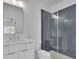 Bathroom with white vanity, toilet, walk-in shower with a glass enclosure, and dark gray tiles at 315 Hillcrest View Drive, Suwanee, GA 30024