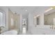 Bright bathroom featuring double vanities with gold hardware, a soaking tub, and a frameless glass shower at 315 Hillcrest View Drive, Suwanee, GA 30024