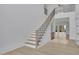 Bright foyer showcasing a staircase with iron railings and wood steps, with a view into the home's light-filled living spaces at 315 Hillcrest View Drive, Suwanee, GA 30024