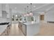 Open-concept kitchen featuring quartz countertops, stainless steel appliances, a large island, and a view of the living area at 315 Hillcrest View Drive, Suwanee, GA 30024