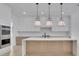 Modern kitchen features an island with pendant lighting, stainless steel appliances, and ample cabinet space at 315 Hillcrest View Drive, Suwanee, GA 30024
