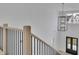 Elegant staircase with wood handrail, black metal balusters, and a modern chandelier at 315 Hillcrest View Drive, Suwanee, GA 30024