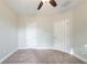A neutral bedroom featuring neutral-toned walls, brown carpet, ceiling fan, and white doors at 4915 Wycliffe Dr, Stone Mountain, GA 30087