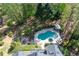 Aerial view of a private backyard oasis with a sparkling pool, spa, fire pit, and lush landscaping at 1450 Chadberry Way, Lawrenceville, GA 30043