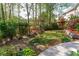 Lush backyard garden with well-manicured lawn, mature trees, and colorful flowers at 1450 Chadberry Way, Lawrenceville, GA 30043