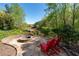 Charming backyard featuring a stone fire pit area with Adirondack chairs, offering a serene outdoor retreat at 1450 Chadberry Way, Lawrenceville, GA 30043