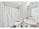 Bathroom featuring a toilet, pedestal sink, and shower with a stylish black and white shower curtain at 1450 Chadberry Way, Lawrenceville, GA 30043