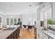 Stylish kitchen showcasing a large island with cooktop, stainless steel appliances, and an adjacent dining area and sunroom at 1450 Chadberry Way, Lawrenceville, GA 30043