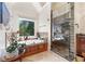 Elegant bathroom featuring a soaking tub, walk-in shower with glass door, and a window view at 1450 Chadberry Way, Lawrenceville, GA 30043