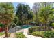Backyard oasis featuring a beautiful pool, lush landscaping, and an inviting seating area perfect for relaxing at 1450 Chadberry Way, Lawrenceville, GA 30043