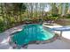 Stunning backyard pool featuring a slide, spa, and lush landscaping, perfect for Gathering fun and relaxation at 1450 Chadberry Way, Lawrenceville, GA 30043