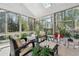 Bright sunroom featuring lots of windows, tile flooring, and comfortable seating with views of the surrounding trees at 1450 Chadberry Way, Lawrenceville, GA 30043