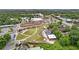 Expansive aerial view of a park featuring tiered seating, green lawns, pedestrian walkways, and mature trees in a suburban area at 207 Magnolia Creek Way, Woodstock, GA 30188