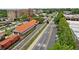 Aerial shot of a charming historic area featuring a railway, train car, quaint building, and lush greenery along the streets at 207 Magnolia Creek Way, Woodstock, GA 30188