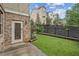 Backyard with well manicured lawn, a fenced in garden, and a brick back door at 207 Magnolia Creek Way, Woodstock, GA 30188