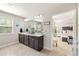 Bathroom with double sink vanity, dark wood cabinets, large mirror, tile floor, and adjacent bedroom at 207 Magnolia Creek Way, Woodstock, GA 30188
