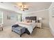 Bright bedroom featuring a tufted headboard, ceiling fan, bench, and natural light from two windows at 207 Magnolia Creek Way, Woodstock, GA 30188