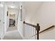 Hallway with staircase, wood railing, carpeted floor, and view of the laundry area at 207 Magnolia Creek Way, Woodstock, GA 30188
