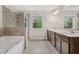Bathroom featuring double sinks, bathtub, shower cabin with glass doors and natural light at 207 Magnolia Creek Way, Woodstock, GA 30188