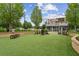 Inviting outdoor patio featuring comfortable seating, a well-maintained lawn, and a stylish building with a rooftop terrace at 207 Magnolia Creek Way, Woodstock, GA 30188