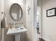 Charming powder room with a pedestal sink, oval mirror, and 'Wash Your Hands' wall decor at 207 Magnolia Creek Way, Woodstock, GA 30188