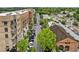 Aerial shot showing a vibrant street with upscale apartments, shops, parked cars, and lush greenery alongside a train track at 207 Magnolia Creek Way, Woodstock, GA 30188