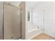 Bathroom with tub, shower, and frosted glass shower door, offering a serene and private bathing experience at 392 Beranda Cir, Douglasville, GA 30134