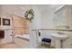 Elegant bathroom with a soaking tub, decorative tile, and a pedestal sink, offering a serene spa-like experience at 55 Hazelbrook Way, Acworth, GA 30101