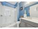 Vibrant blue bathroom featuring a glass enclosed shower, mosaic tiled floors and a sleek, modern vanity at 115 Harlow Cir, Roswell, GA 30076